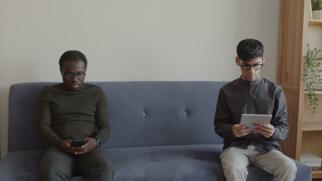 Men Using Digital Devices on Sofa