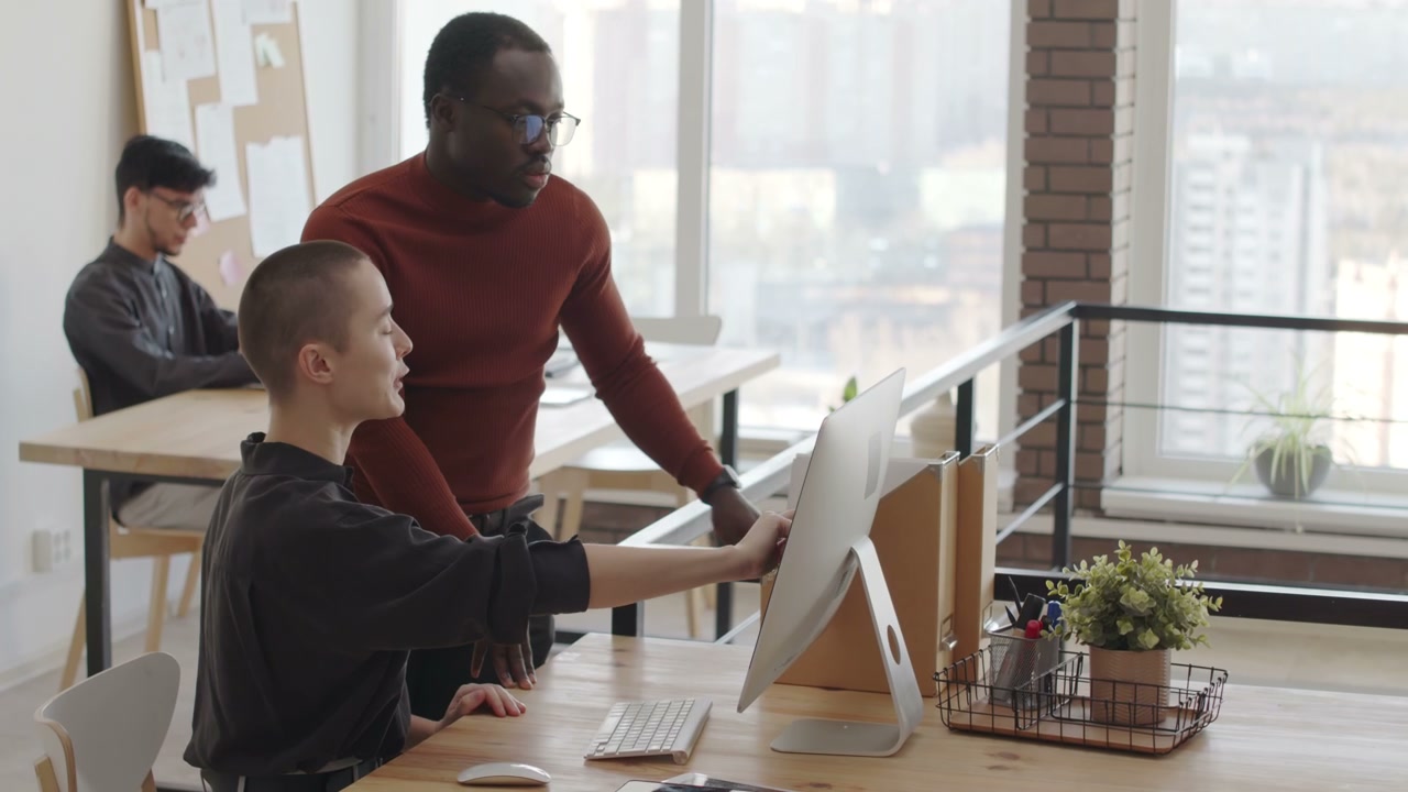 Coworkers Discussing Project on Computer in Office
