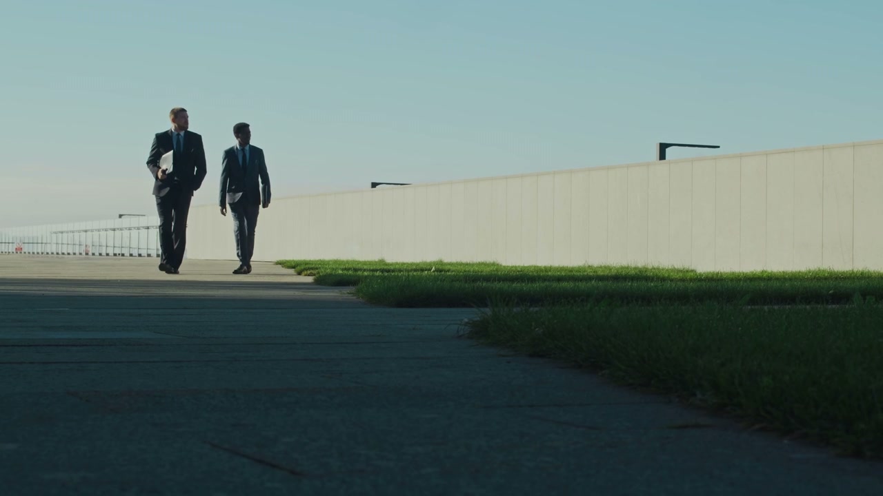 Two Businessmen Walking on Outdoor Pathway