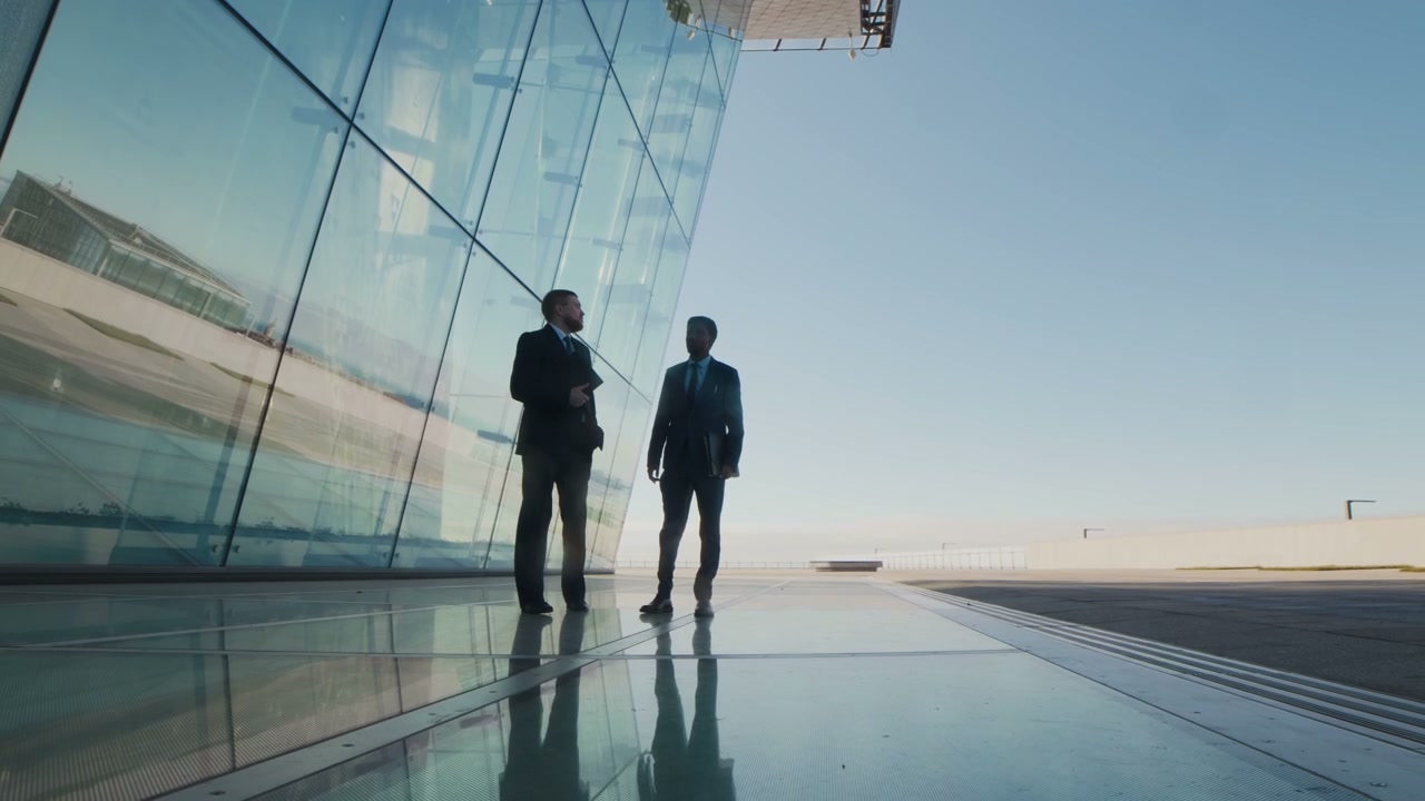 Businessmen Shake Hands Outside Glass Skyscraper
