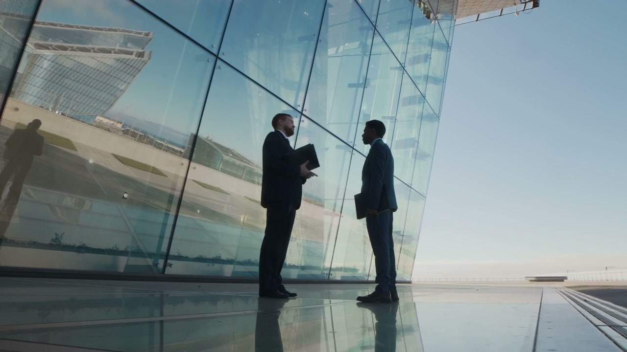 Two Businessmen Discussing Outside Skyscraper