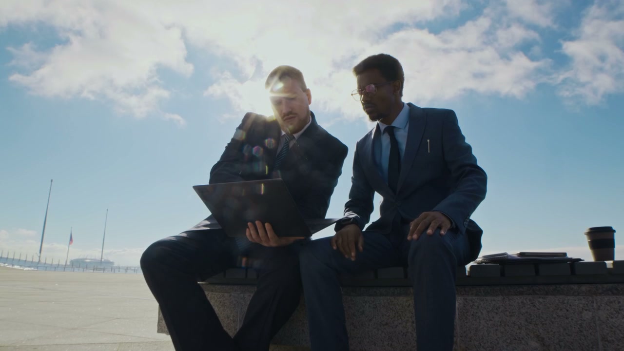 Two Businessmen Discussing on Laptop Outdoors