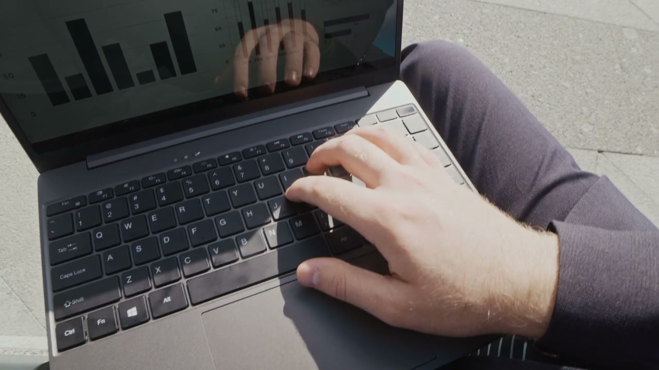 POV Man Typing on Laptop Outdoors with Coffee