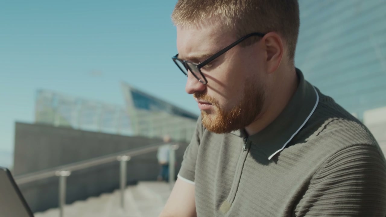 Two Men Working on Laptop Outdoors