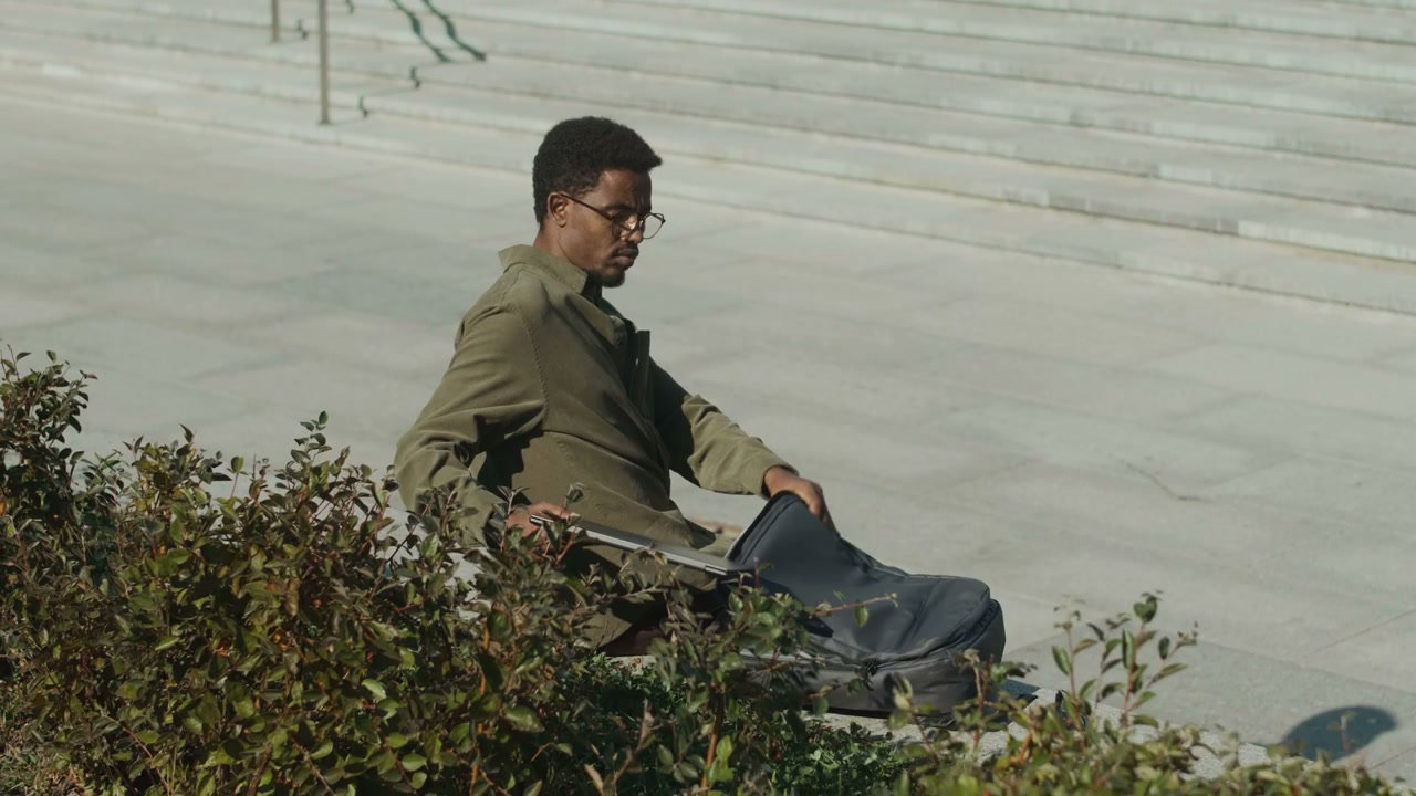Man Preparing Laptop on Urban Steps