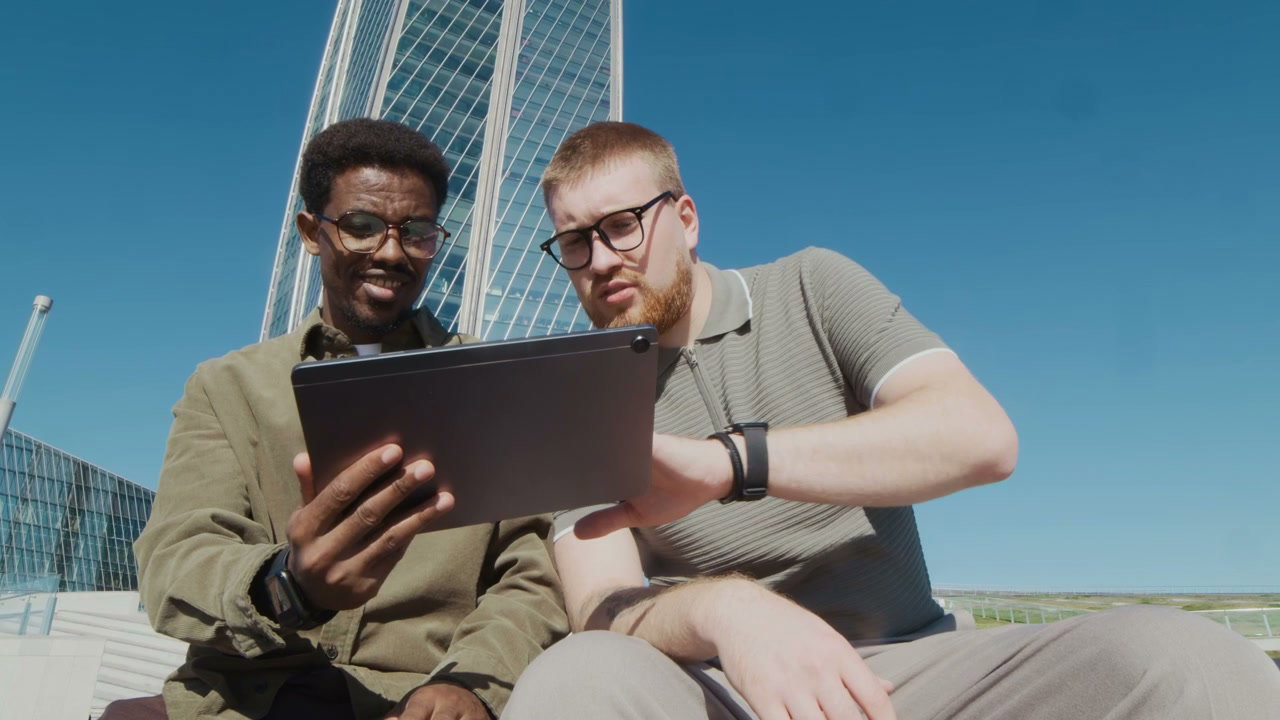 Two Men Discussing on Tablet Near Lakhta Center