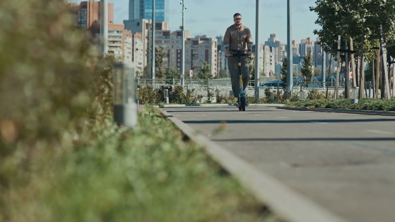 Man Riding Electric Scooter in Urban Park