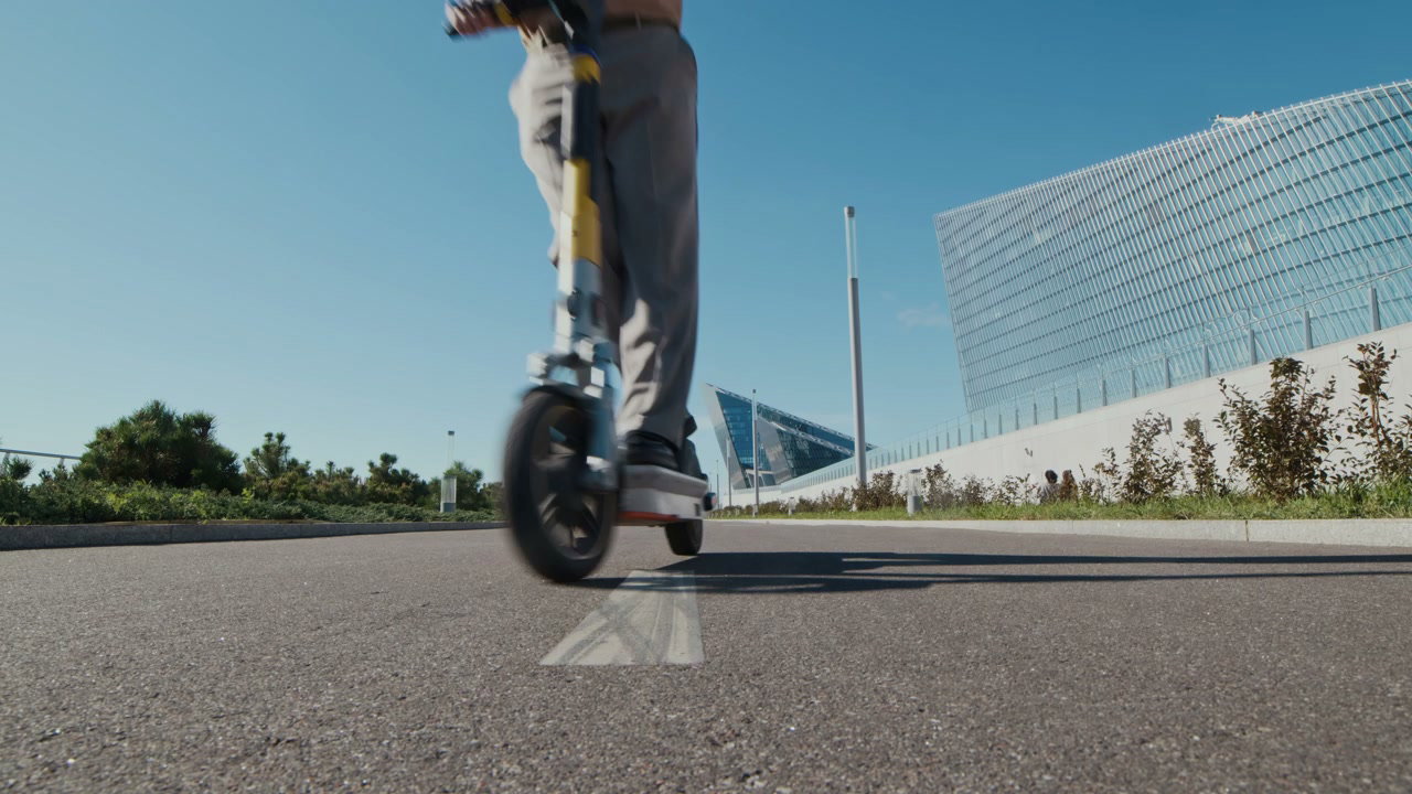 Man Riding Electric Scooter in Modern City