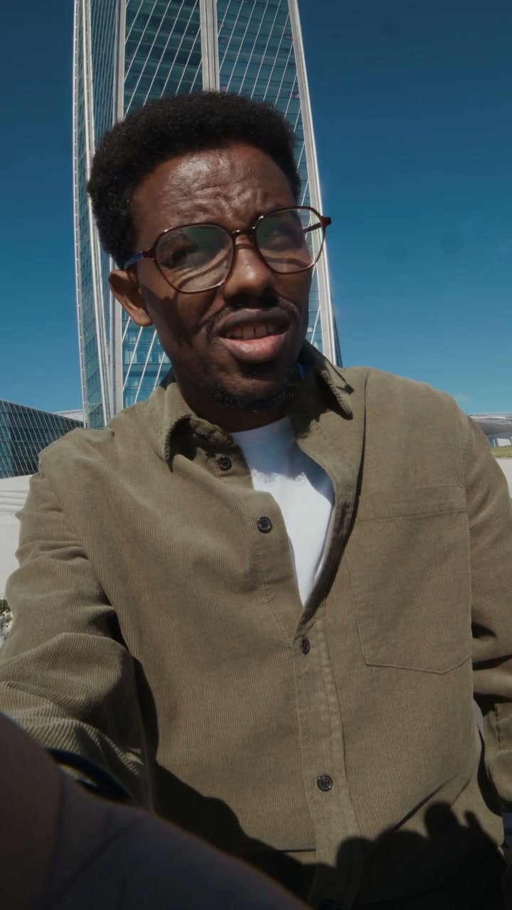 Black Man Vlogging Outdoors by Skyscraper