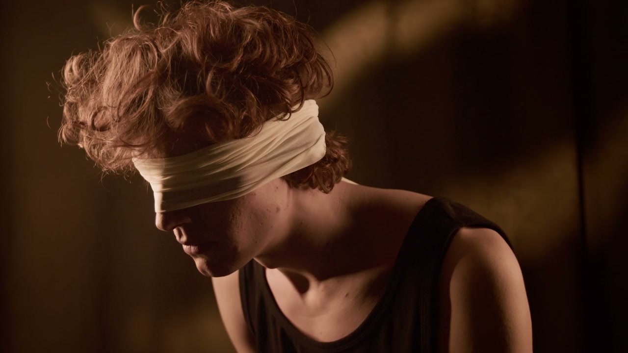 Young Person Blindfolded in Dark Studio
