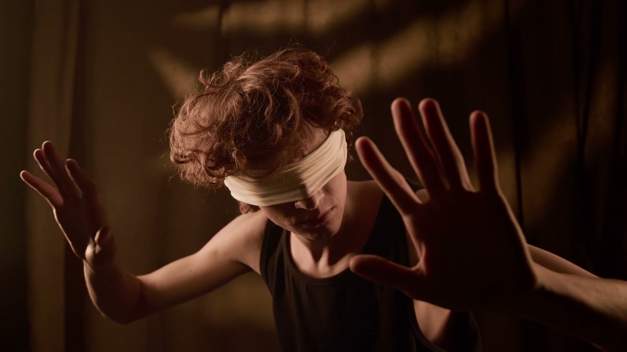 Blindfolded Man Struggling in Studio