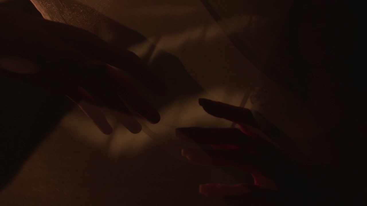 Silhouetted Hands Reaching Through Fabric