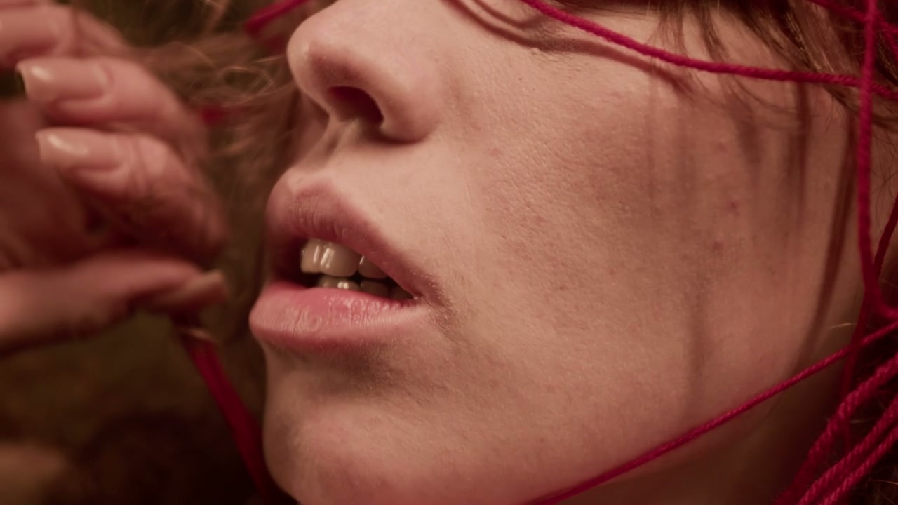 Close Up of Person Tangled in Red Threads