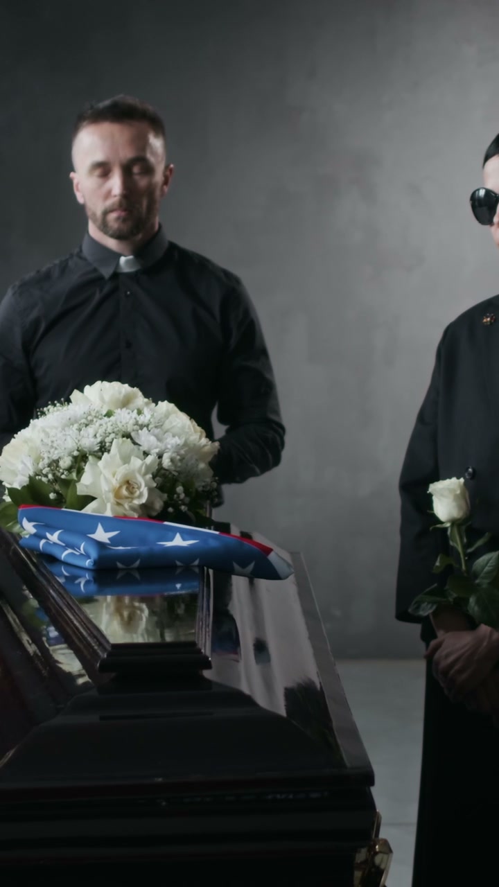 Mourners at Funeral with American Flag on Coffin