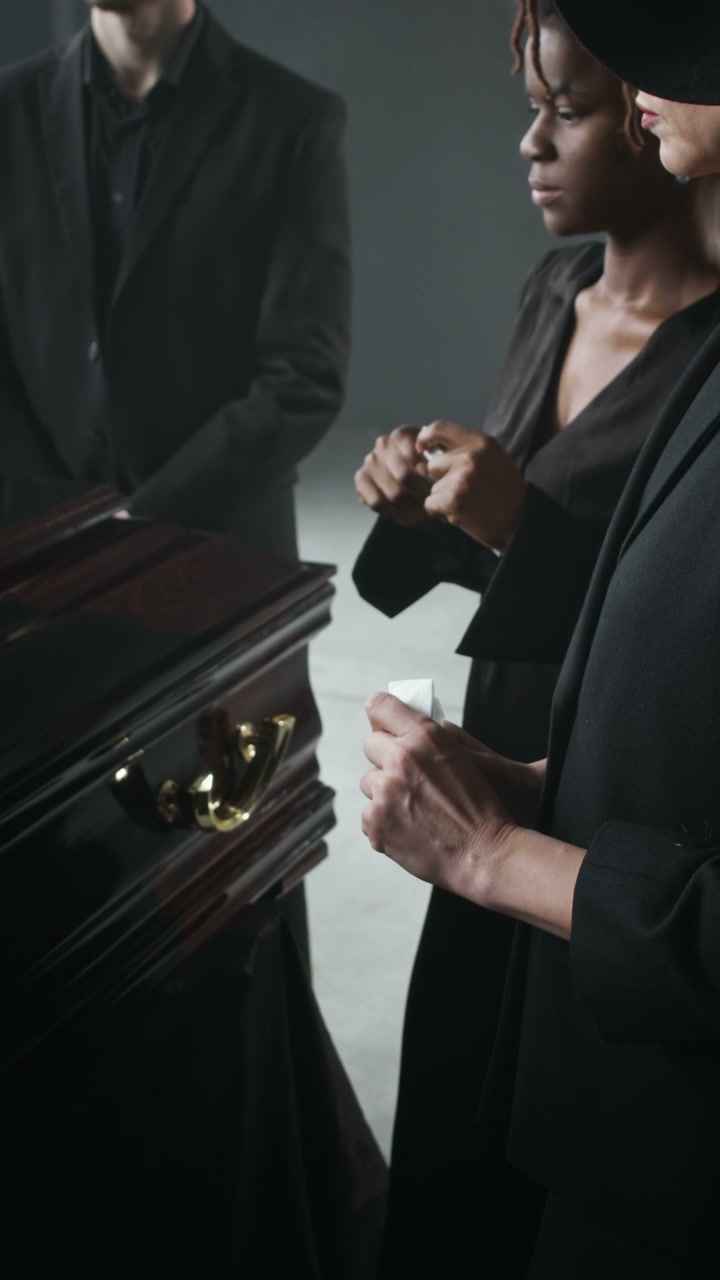 Mourners Grieving by a Coffin at Funeral Service