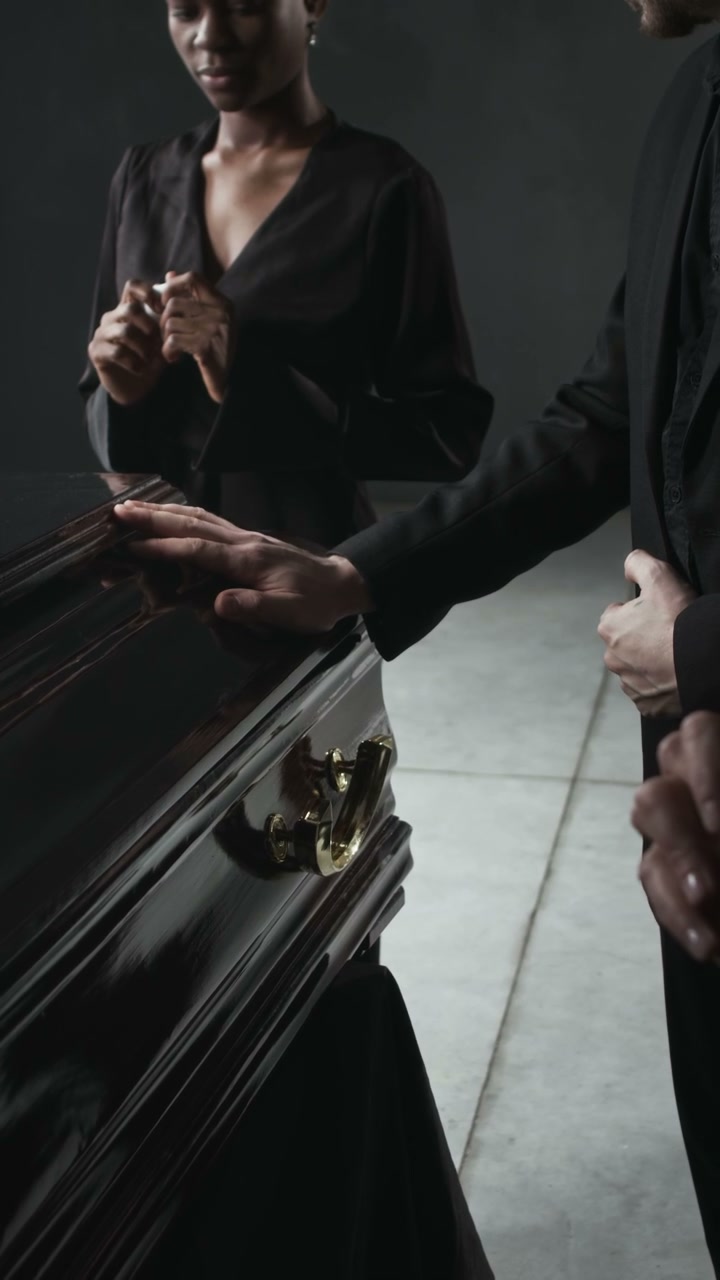 Mourners Standing by a Coffin at a Funeral