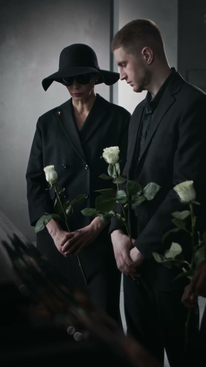 Mourners Holding White Roses at Funeral Service