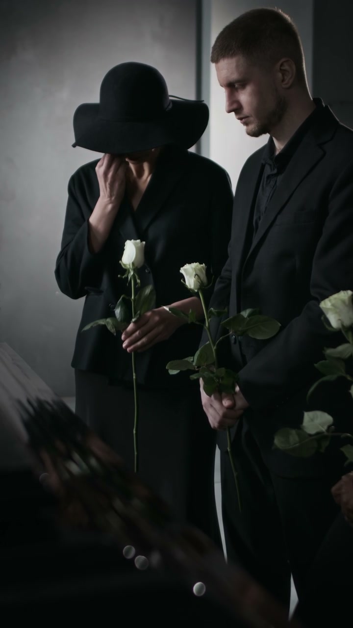 Mourners Holding Flowers at Funeral Service