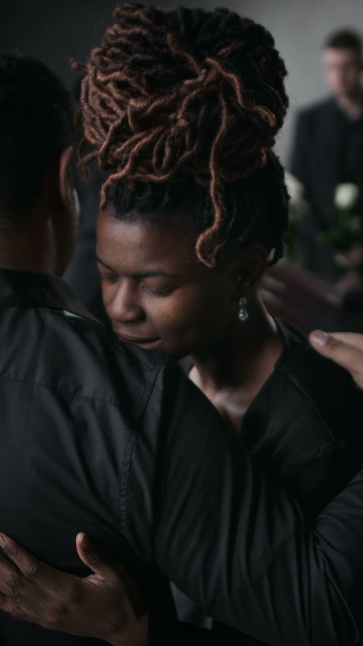 Mourning Woman Embraced at Funeral Service