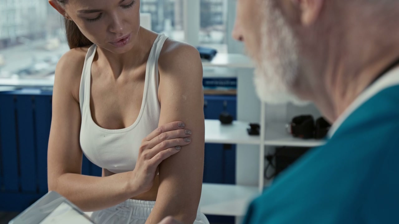 Young Woman Consulting Doctor About Arm Injury