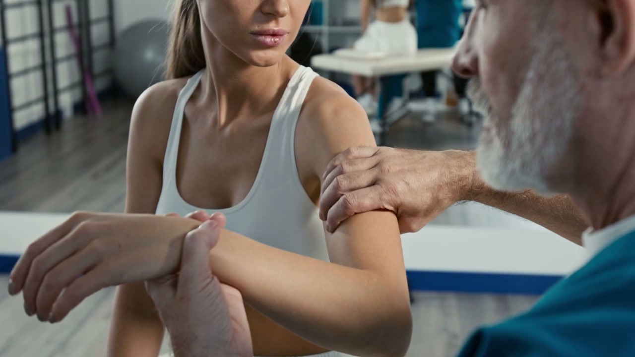 Physiotherapist Examining Woman's Arm in Clinic