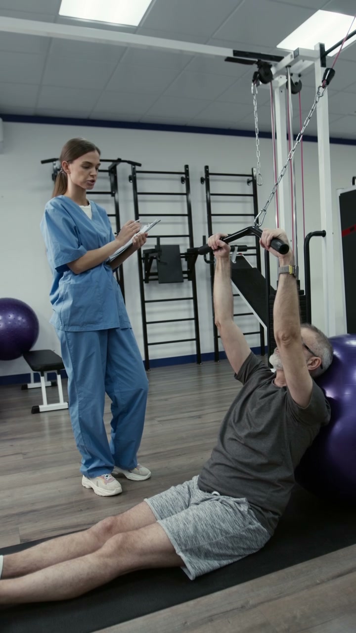 Senior Man Assisted in Rehabilitation Exercise