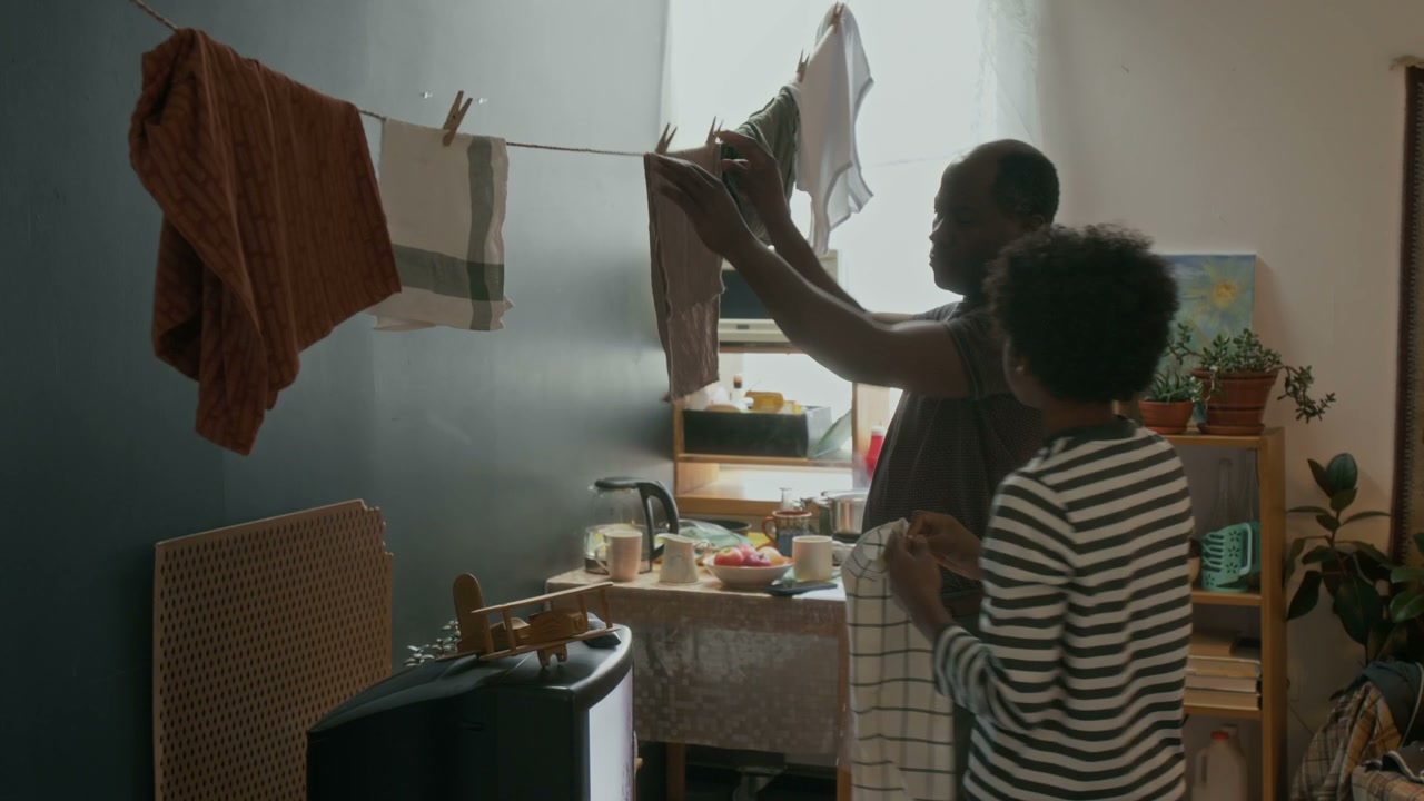 Father and Son Hanging Laundry Indoors