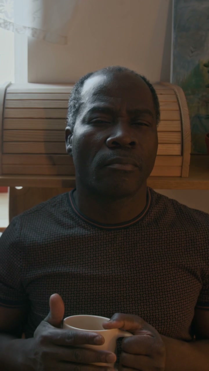 Man Holds Mug and Opens Eyes