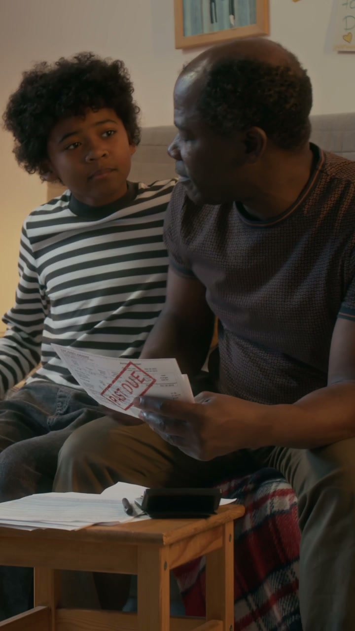 Father and Son Looking at Past Due Bill