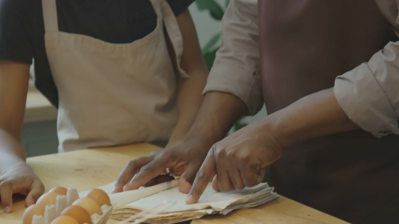Grandfather and Grandson Read Cookbook in Kitchen
