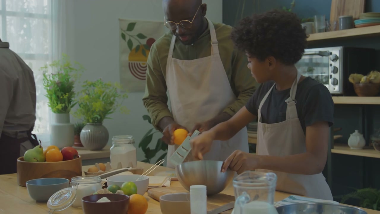 Family Zesting Orange in Kitchen