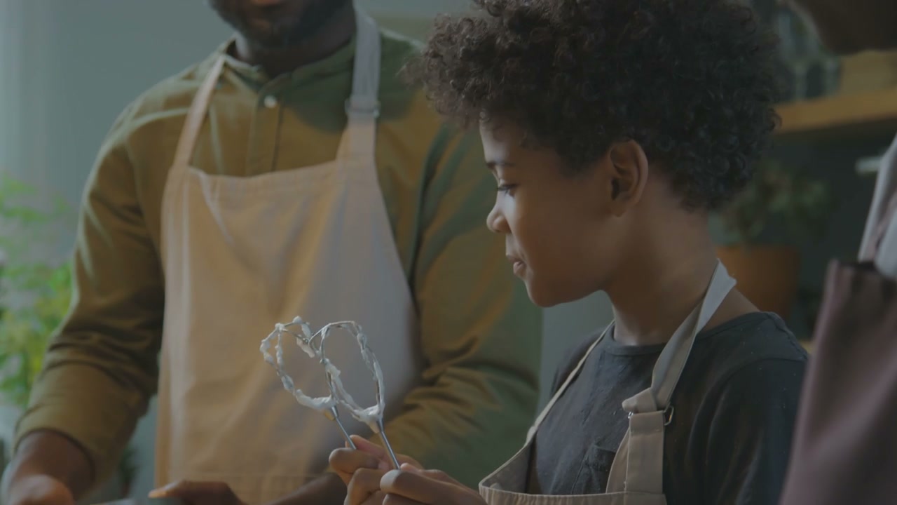 Child Licking Whisk While Cooking with Adult