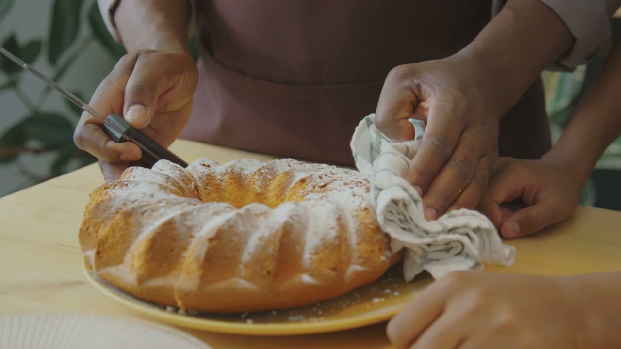 Close-Up of Hands Slicing Cake