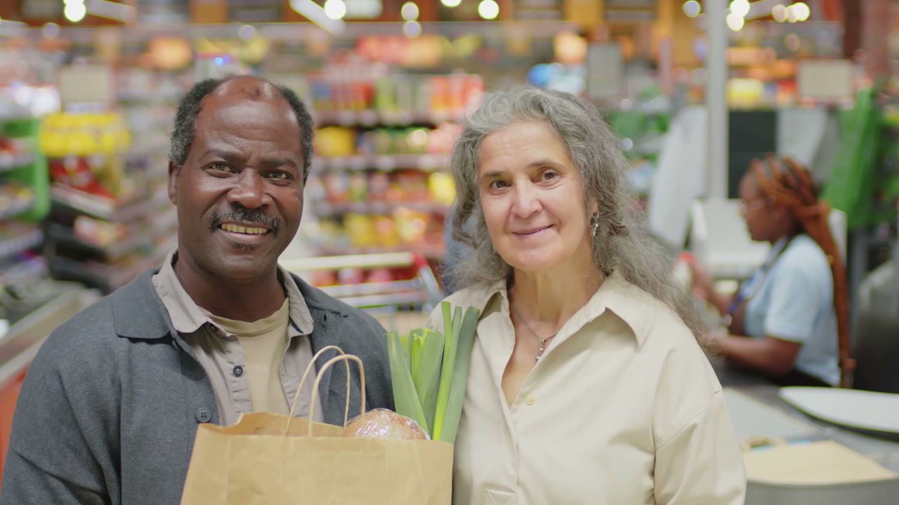 Smiling Senior Couple With Groceries in Supermarket