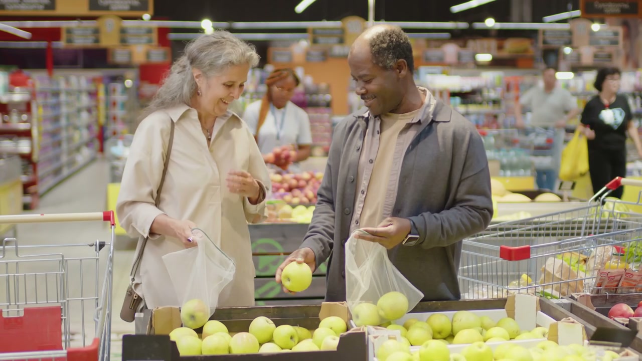 Senior Couple Shopping for Apples in Supermarket