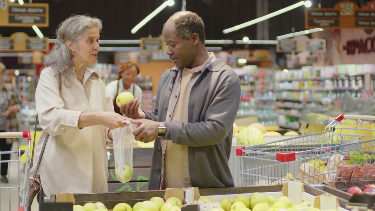 Diverse Couple Picking Apples in Supermarket