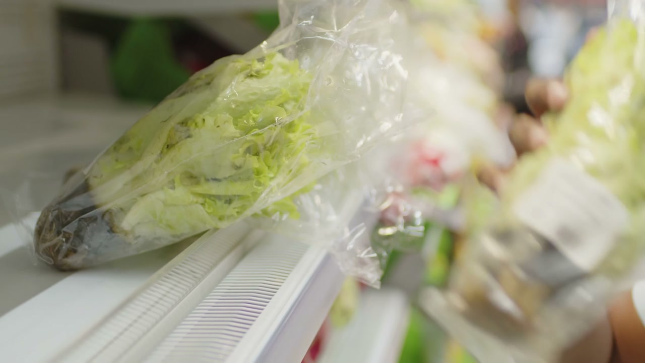 Supermarket Worker Stocking Lettuce
