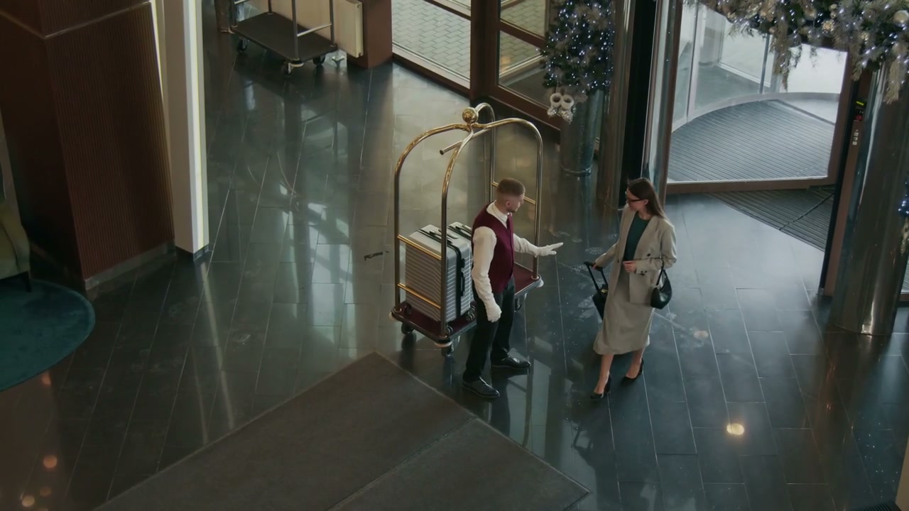 Hotel Bellhop Helping Guest with Luggage