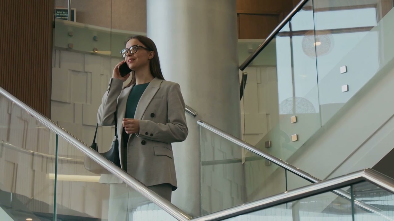 Professional Woman on Phone Walking Down Stairs