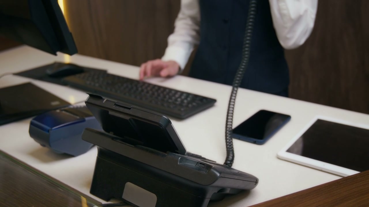 Receptionist Answering Phone at Hotel Desk