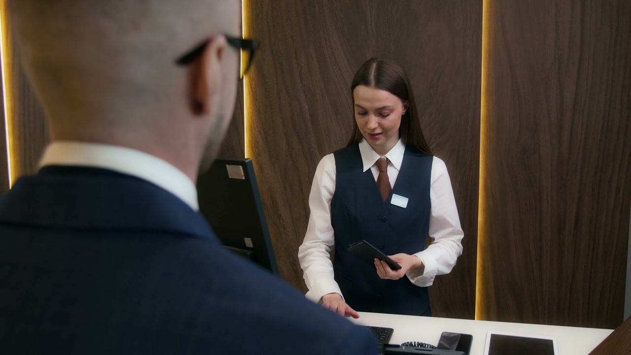 Hotel Receptionist Gives Key Card to Guest