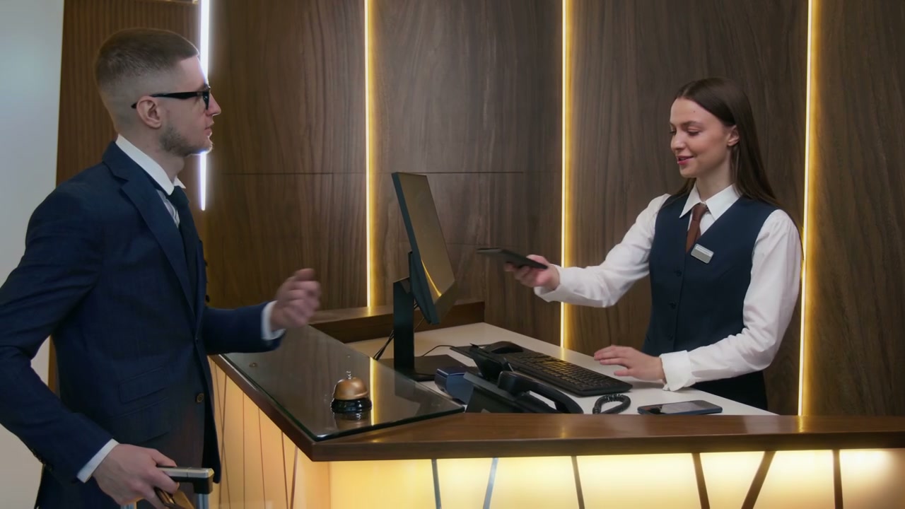 Man Checking In at Hotel Reception