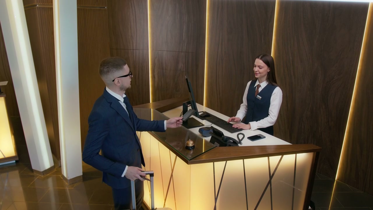 Business Traveler Checking In at Hotel Reception