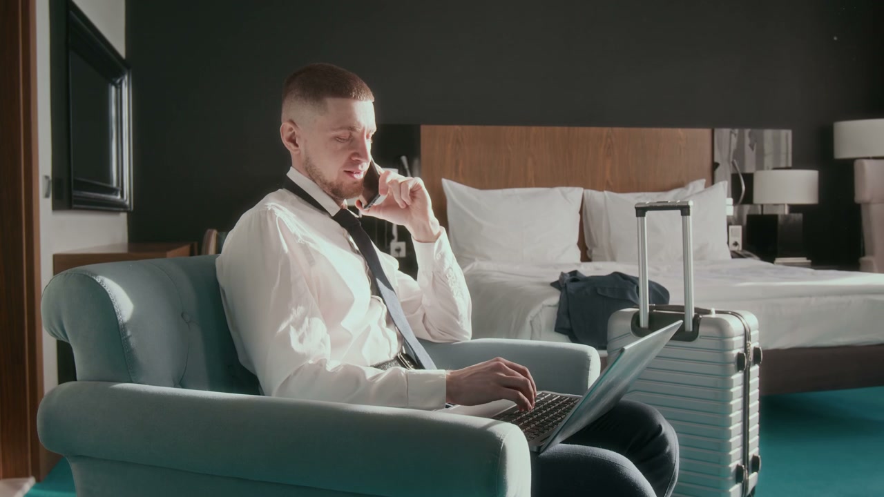 Businessman Talking on Phone in Hotel Room
