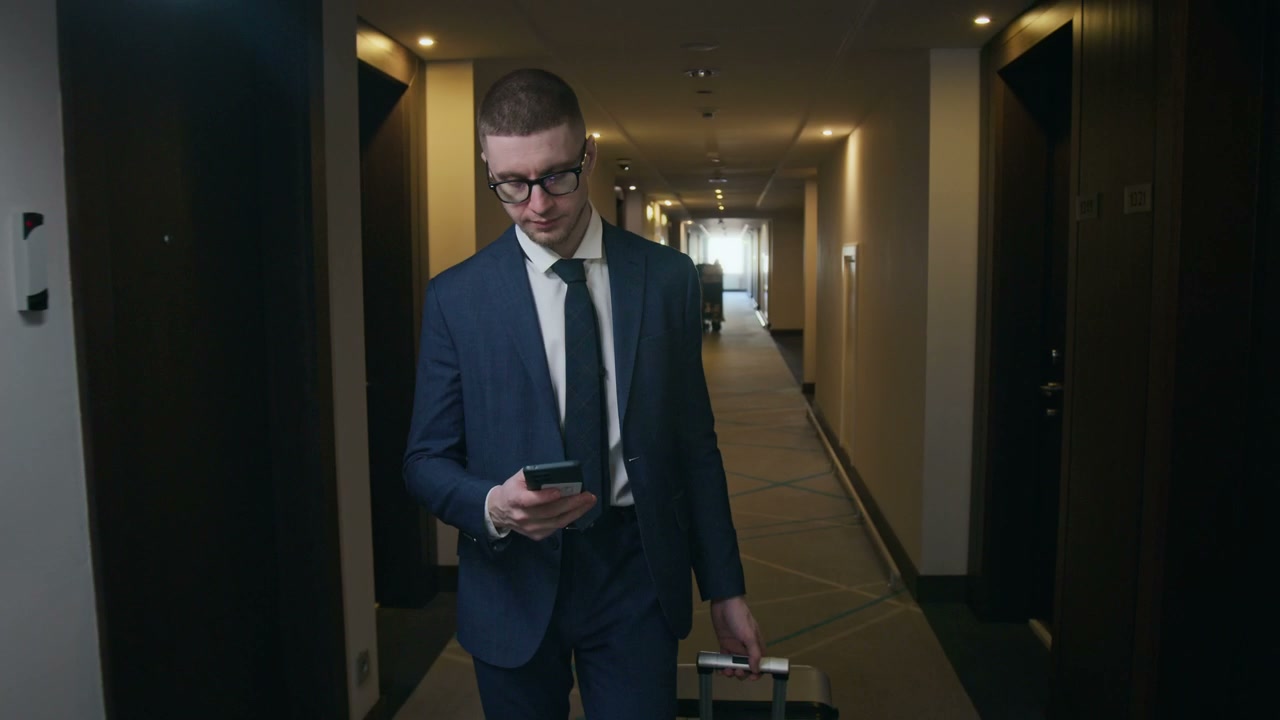 Businessman Walking Hotel Hallway, Using Phone