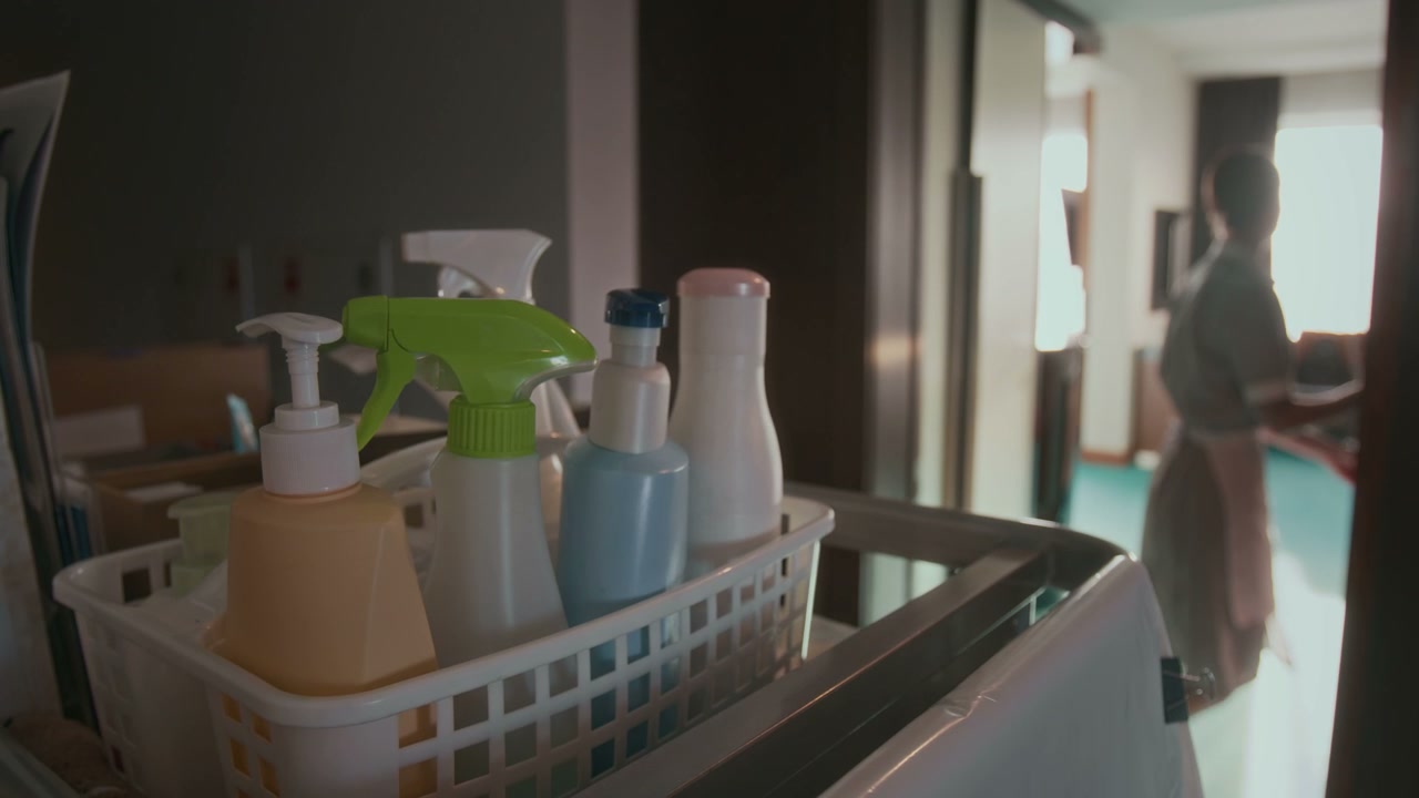 Hotel Housekeeper Takes Cleaning Supplies