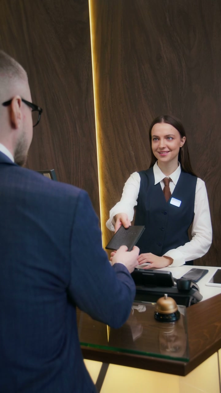 Hotel Receptionist Checks Guest Passport