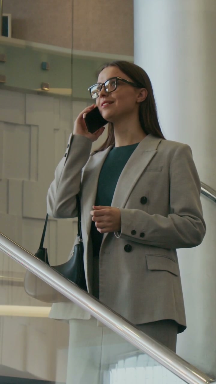 Smiling Woman on Phone in Hotel Staircase