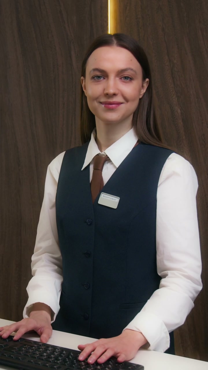 Smiling Hotel Receptionist at Desk