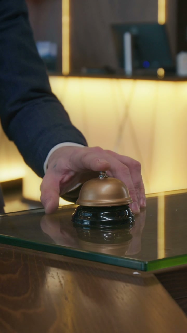 Close-Up of Hand Ringing Hotel Bell